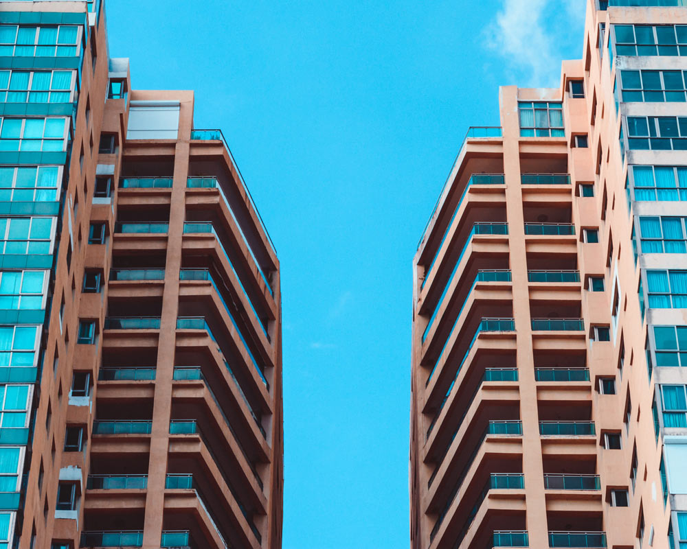 Two high rise buildings under blue sky